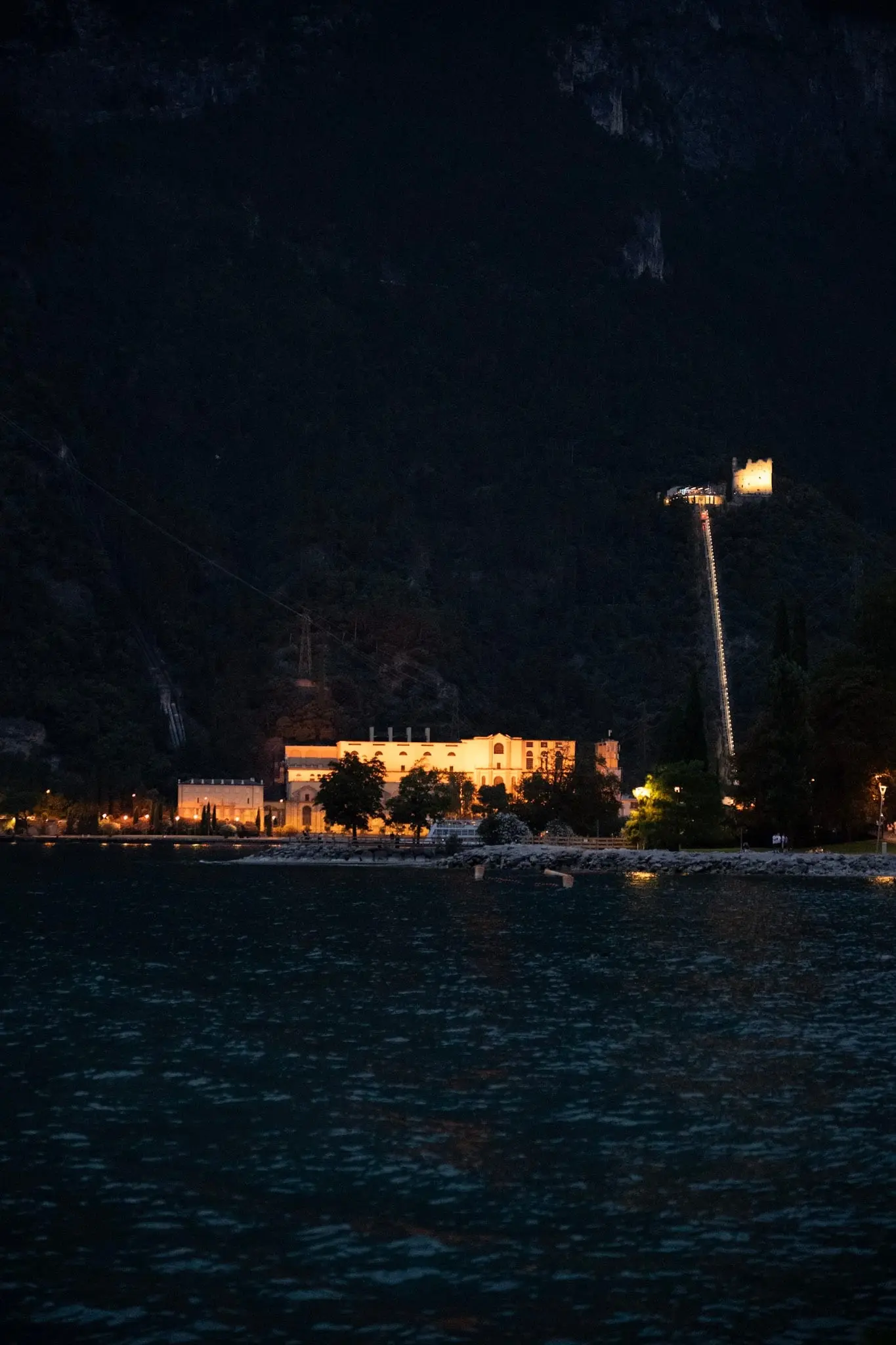 Beleuchtetes Gebäude am Seeufer am späten Abend