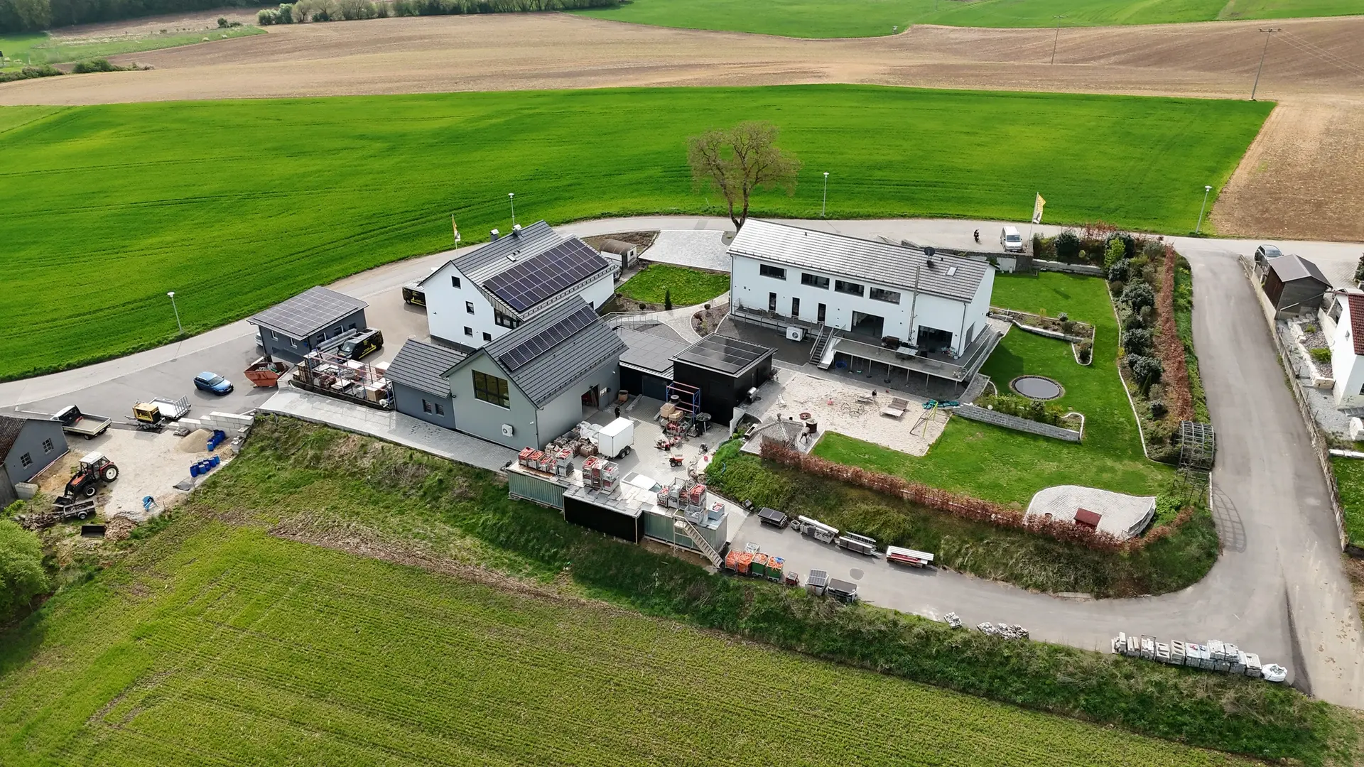 Firmengelände mit Solardächern zwischen Feldern aus der Luft
