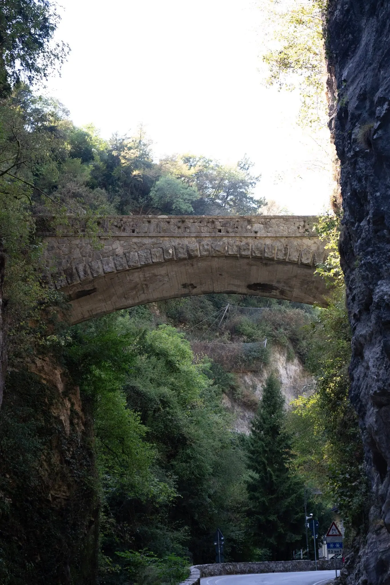 Steinbrücke über einer bewachsenen Schlucht