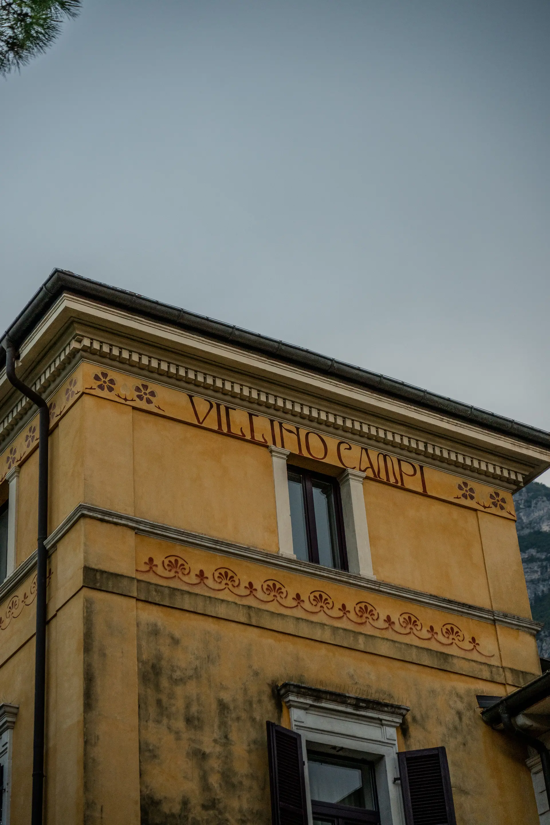 Gelbe Fassade eines historischen Gebäudes mit Inschrift und Ornamentfries
