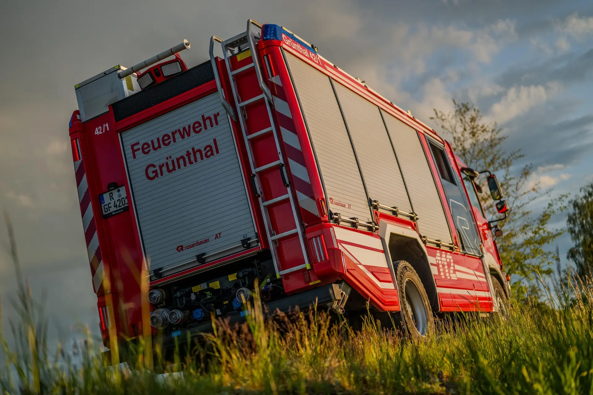 Löschfahrzeug der Feuerwehr aus der Froschperspektive im hohen Gras