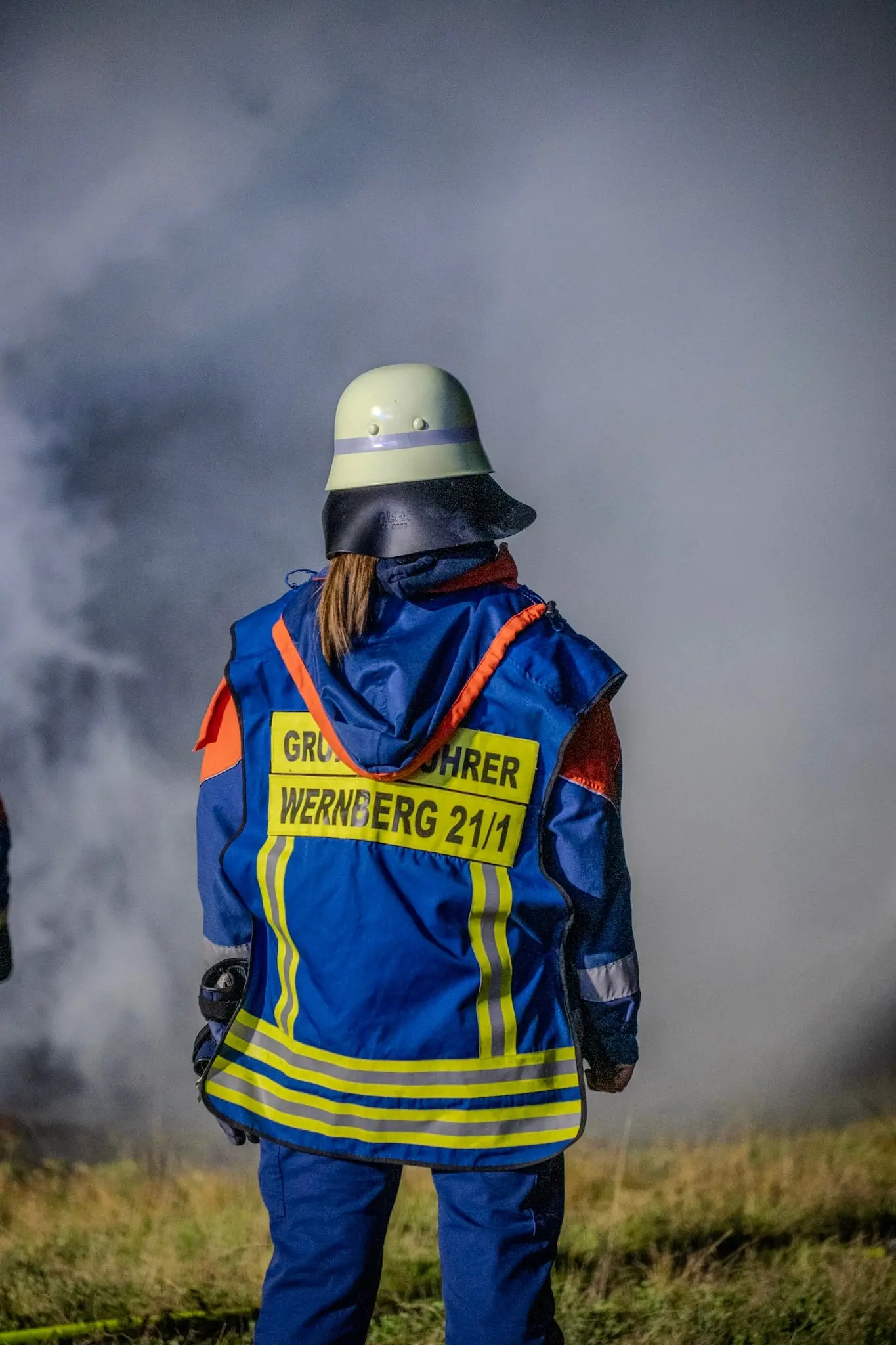 Mitglied der Jugendfeuerwehr Wernberg vor Rauch, von hinten fotografiert