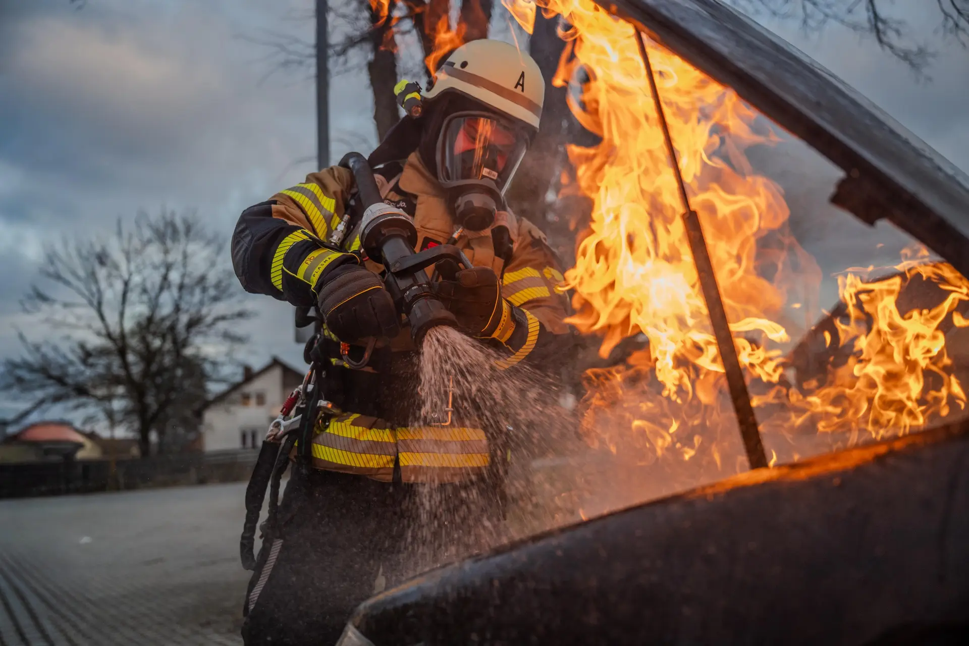 Feuerwehrmann unter Atemschutz löscht einen brennenden Pkw
