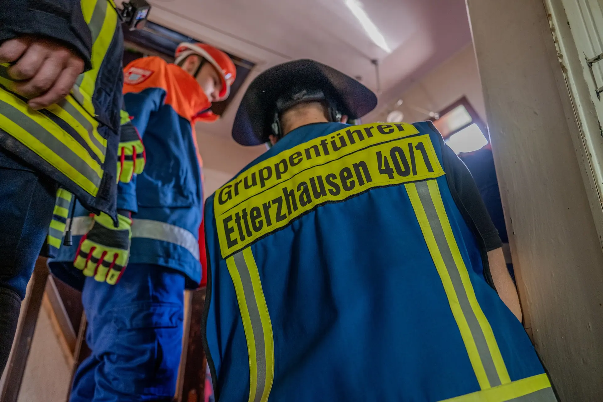 Gruppenführer und Jugendfeuerwehr betreten bei einer Übung ein Gebäude