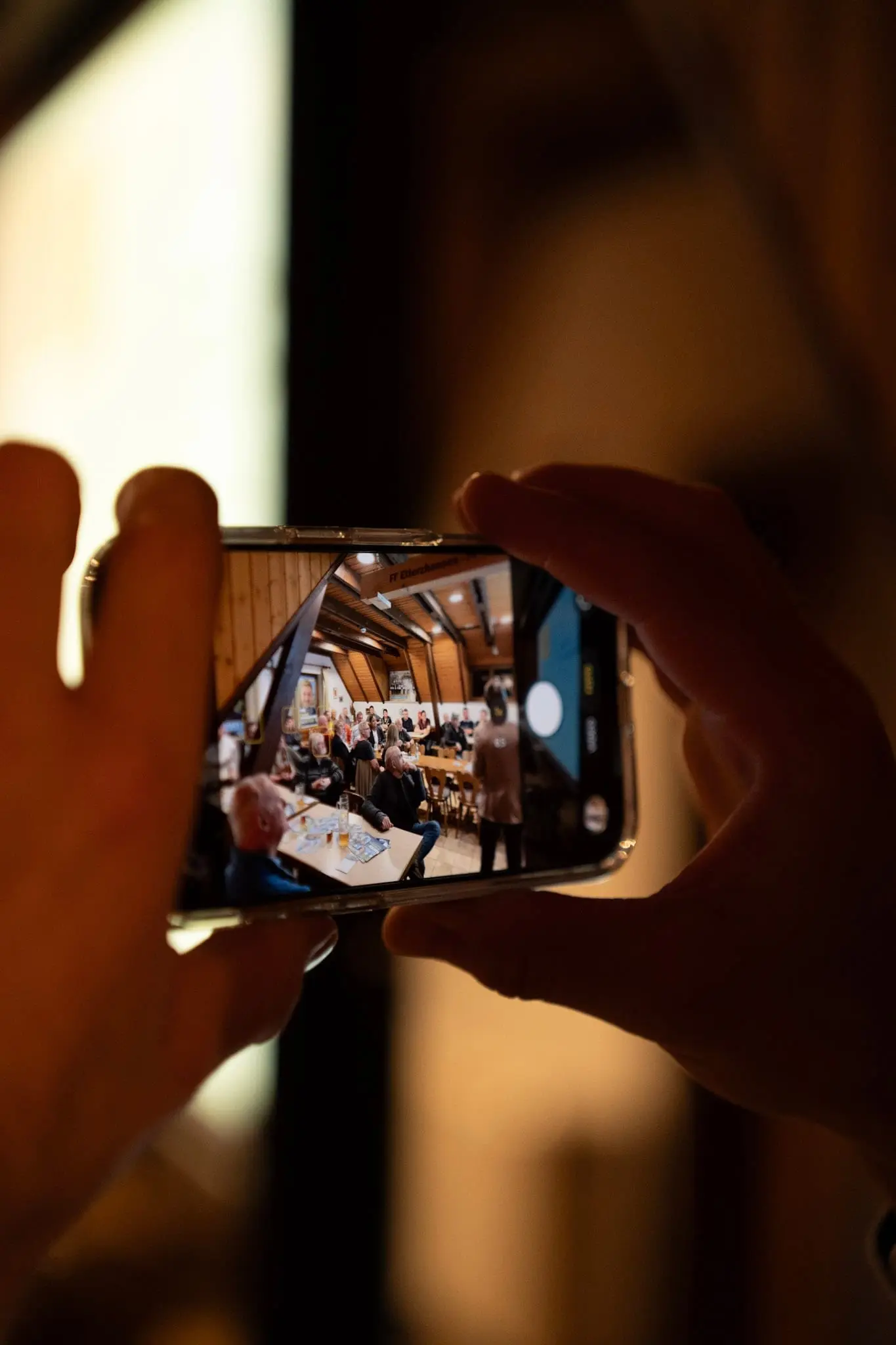 Smartphone filmt eine Veranstaltung im Gastraum